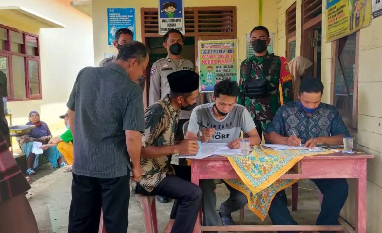 Sinergitas Babinsa Koramil 406-09/Terawas Serda Adi Susanto bersama Bhabinkamtibmas Polsek Terawas Briptu Andre Pantau Vaksinasi Di Balai Desa