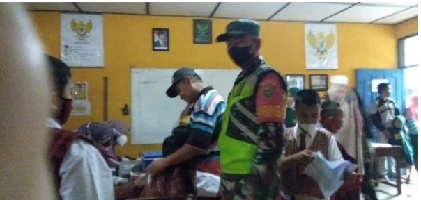 Monitoring Vaksinasi, Babinsa Koramil 06/Cempaka Semangati Anak SD Tak Takut Divaksin